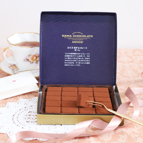 Image shows chocolates in an open box with pink background