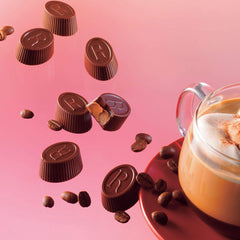 Image shows an array of chocolate cups and a cup of coffee.