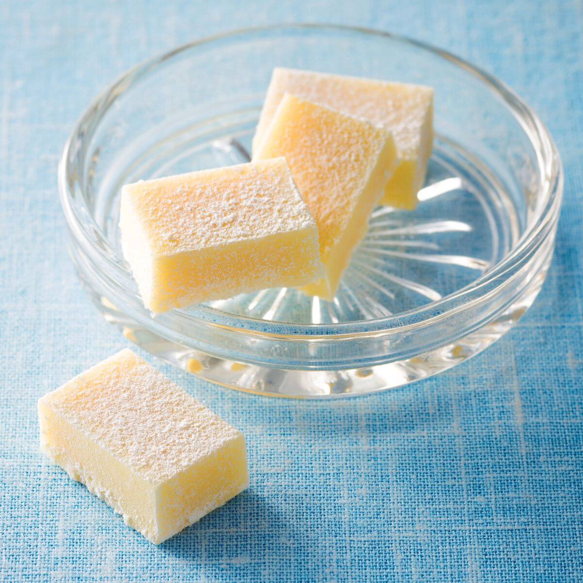 ROYCE' Chocolate - Nama Chocolate "White" - Image shows white blocks of chocolates on a clear plate. Background is in blue.