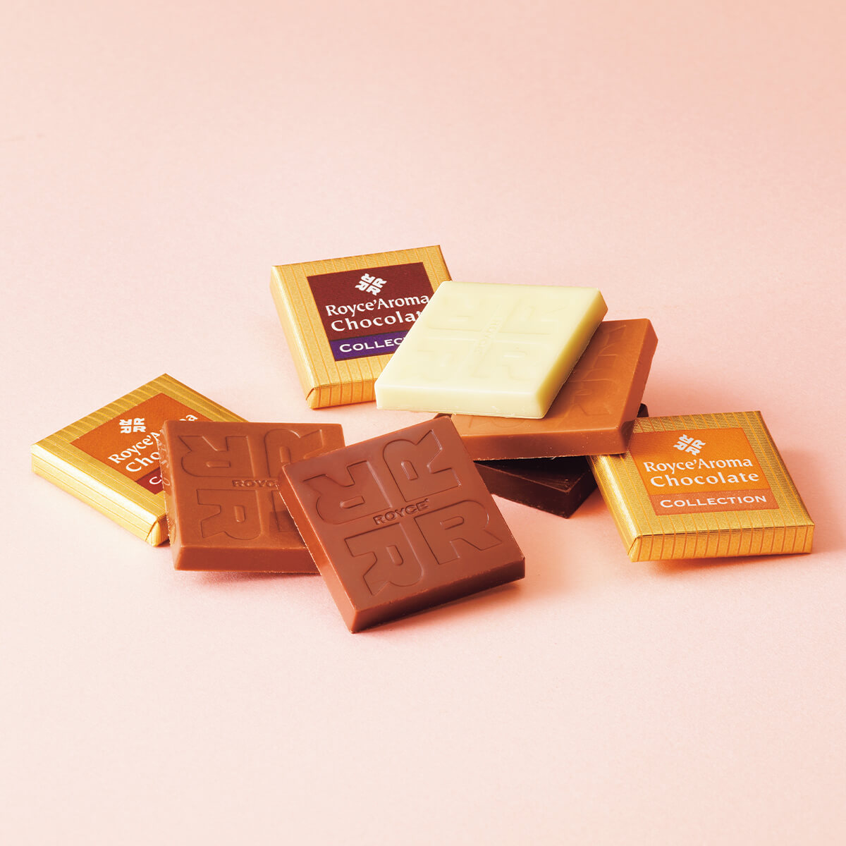 ROYCE' Chocolate - Image shows unwrapped and wrapped chocolate squares in brown, gold, and white.